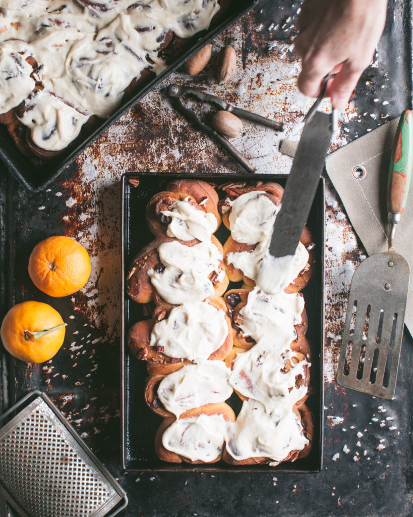 Spreading glaze over cinnamon rolls