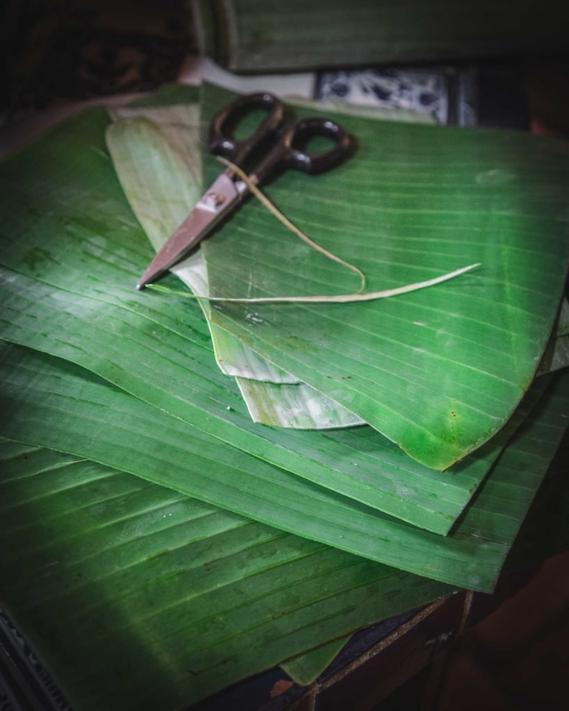 Trim spines from banana leaves