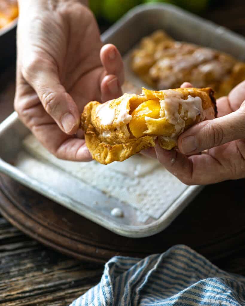 hands breaking open peach fried pie