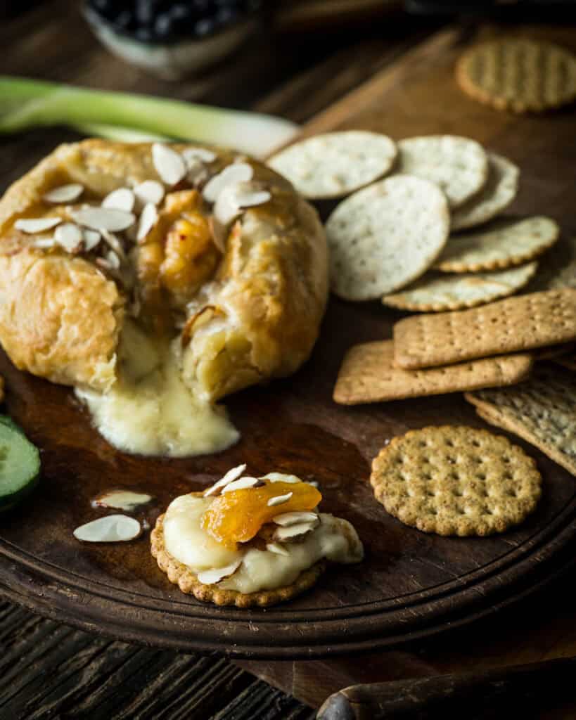 close up image of cracker with dollop of baked brie